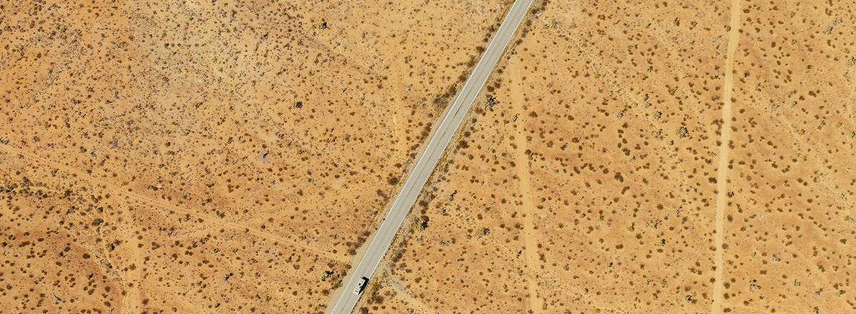 Aerial view of a straight road crossing open Arizona desert